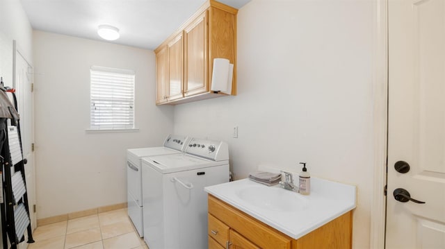 laundry area featuring a sink, baseboards, light tile patterned floors, cabinet space, and separate washer and dryer