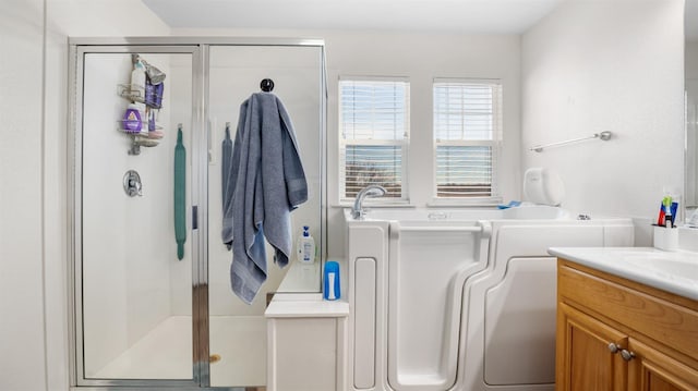 full bathroom with vanity, a bath, and a stall shower