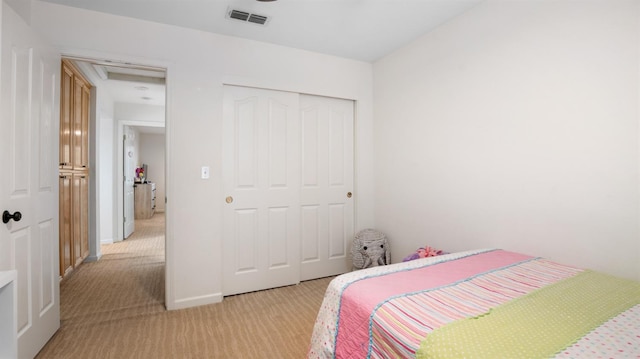 bedroom with visible vents, a closet, baseboards, light colored carpet, and attic access