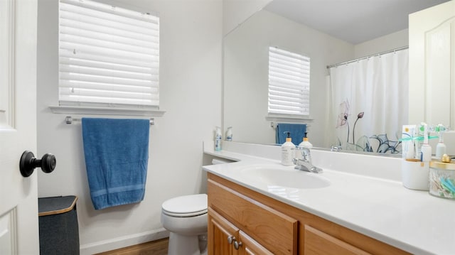 full bath featuring vanity, a shower with curtain, wood finished floors, baseboards, and toilet