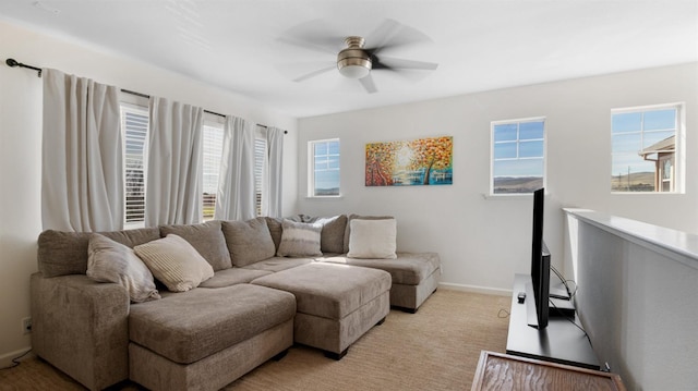 living room featuring baseboards, light colored carpet, and a ceiling fan