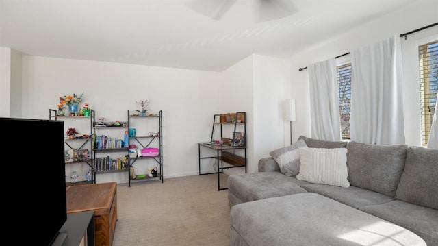 carpeted living room featuring a ceiling fan and baseboards