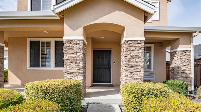 view of exterior entry with stucco siding and stone siding