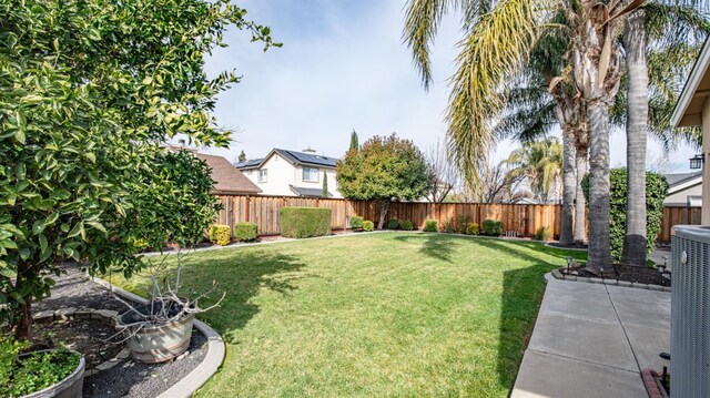 view of yard with central AC, a fenced backyard, and a patio area