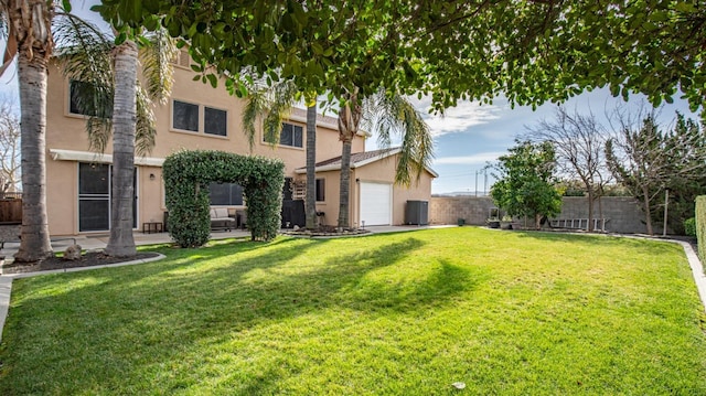 view of yard with central AC and fence