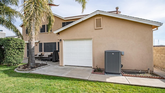 exterior space with fence, central AC unit, stucco siding, a yard, and driveway