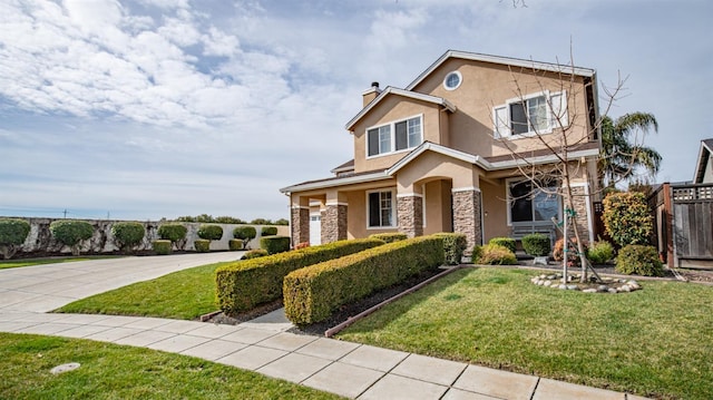 view of front of property with concrete driveway, a front yard, stucco siding, a garage, and stone siding