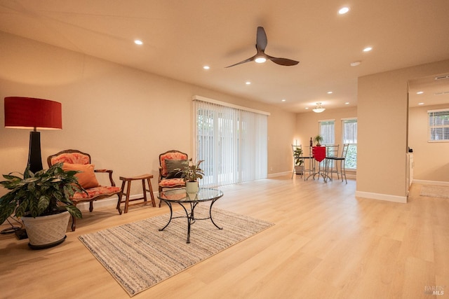 living area with ceiling fan and light hardwood / wood-style floors