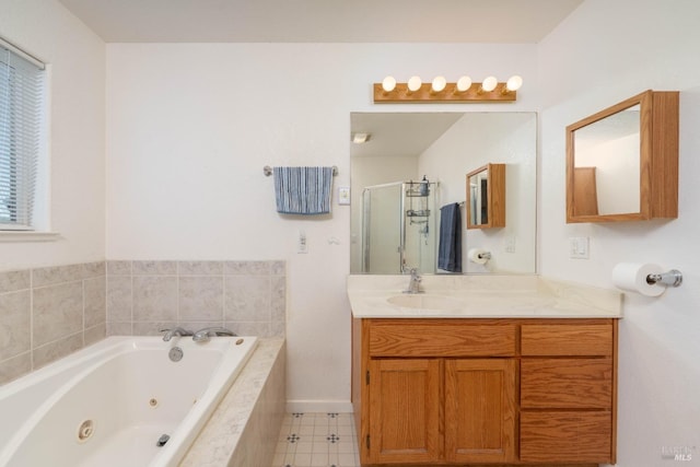 bathroom featuring a tub with jets, a stall shower, vanity, and baseboards