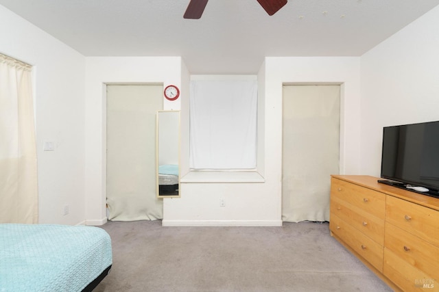 bedroom featuring a ceiling fan, light colored carpet, and baseboards