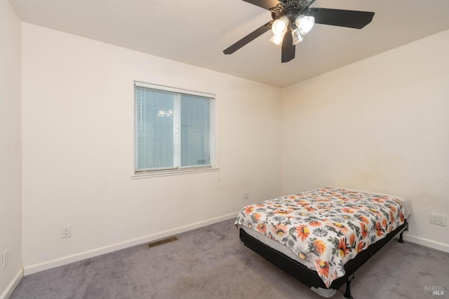 bedroom featuring baseboards, visible vents, a ceiling fan, and light colored carpet