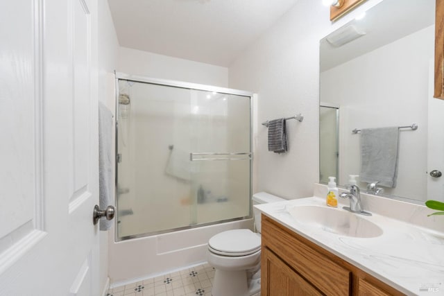 full bathroom with enclosed tub / shower combo, vanity, toilet, and tile patterned floors