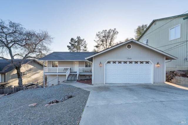 view of front facade featuring concrete driveway, an attached garage, and stairs