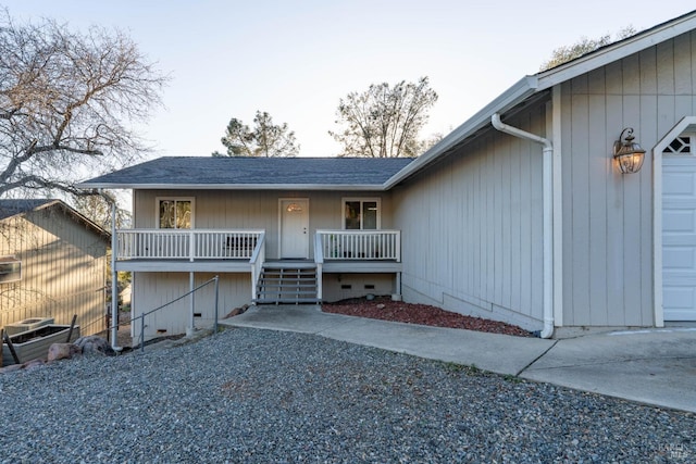 view of front facade with covered porch, roof with shingles, an attached garage, and central air condition unit