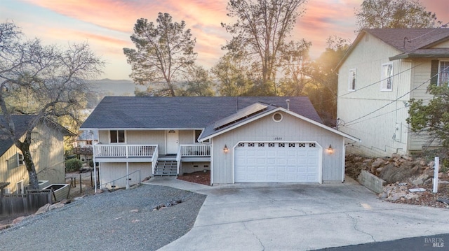 view of front of house featuring a garage, concrete driveway, and covered porch