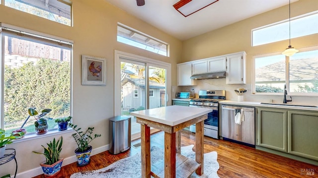 kitchen with hanging light fixtures, light hardwood / wood-style floors, sink, and appliances with stainless steel finishes