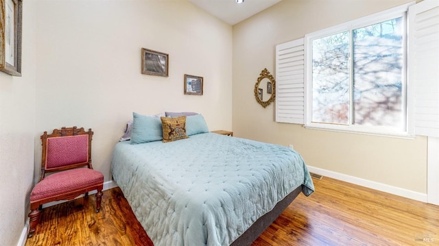 bedroom featuring multiple windows and hardwood / wood-style floors