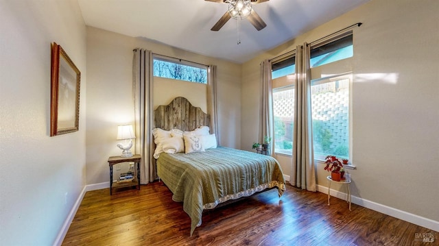 bedroom featuring multiple windows, dark wood-type flooring, and ceiling fan