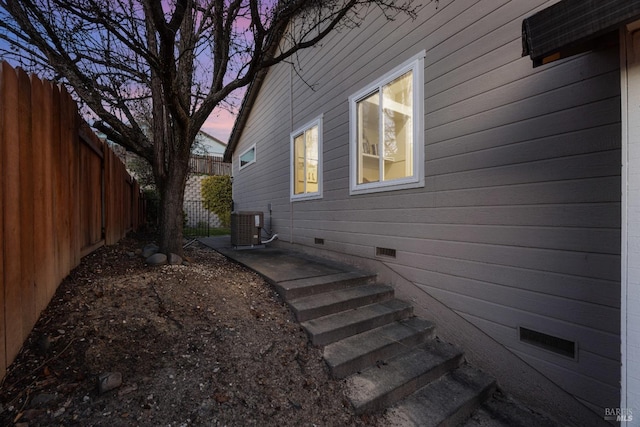 property exterior at dusk featuring central AC unit