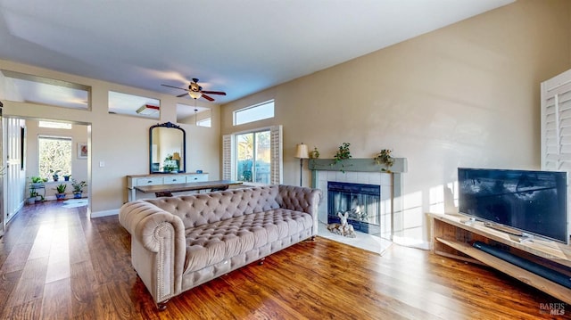 living room featuring a fireplace, wood-type flooring, and ceiling fan