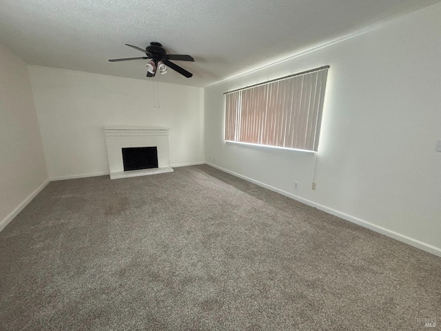 unfurnished living room with ceiling fan, a fireplace, carpet, and a textured ceiling