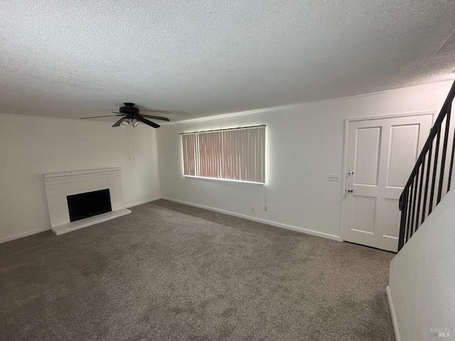 unfurnished living room with a textured ceiling, ceiling fan, and carpet