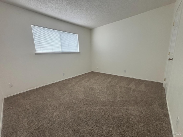 carpeted spare room featuring a textured ceiling