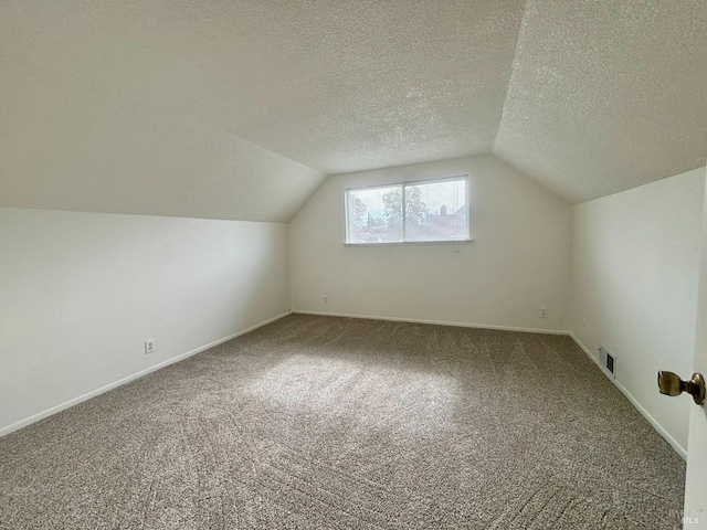 bonus room featuring lofted ceiling, a textured ceiling, and carpet flooring