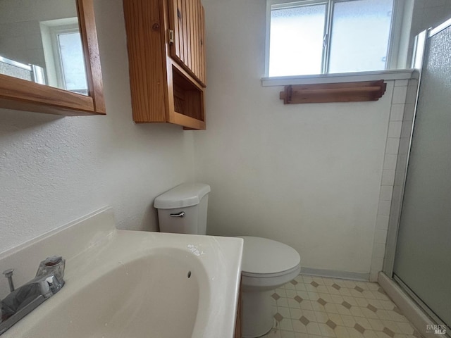 bathroom with toilet, a shower with shower door, and sink