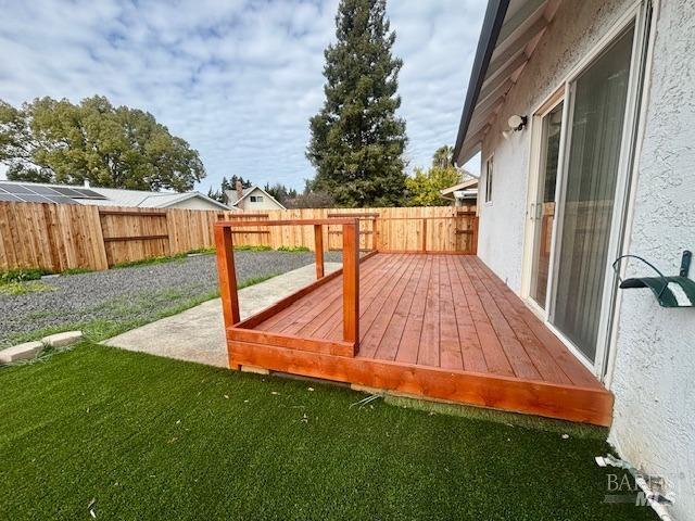 wooden terrace featuring a yard and a patio area