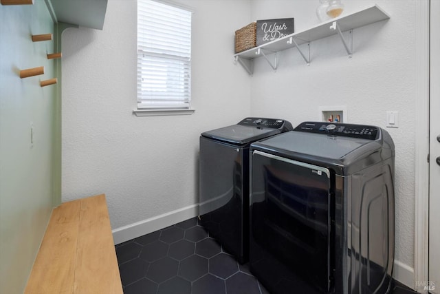 laundry area with dark tile patterned floors and washer and dryer