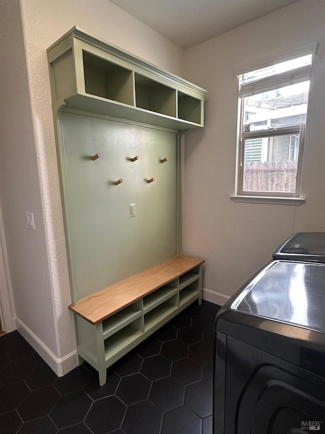 laundry area with washer and dryer and dark tile patterned floors