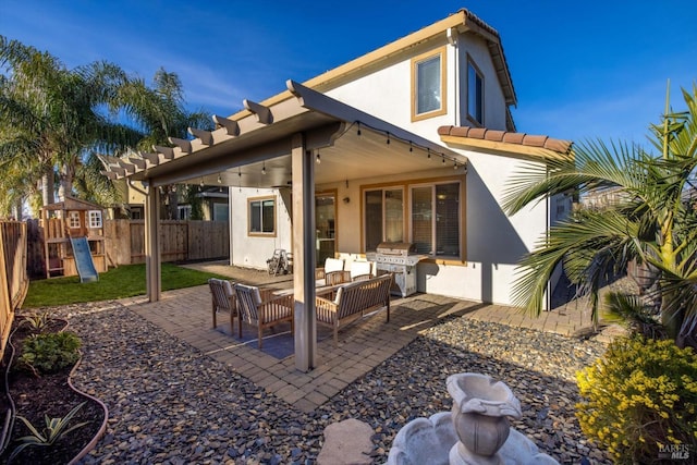 rear view of property featuring outdoor lounge area, a playground, and a patio