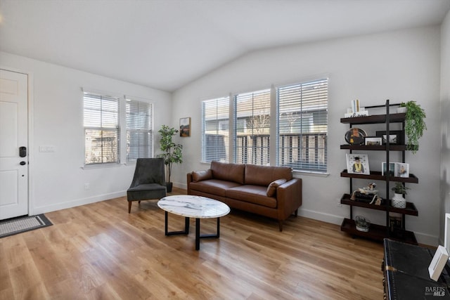 living area with vaulted ceiling and light wood-type flooring