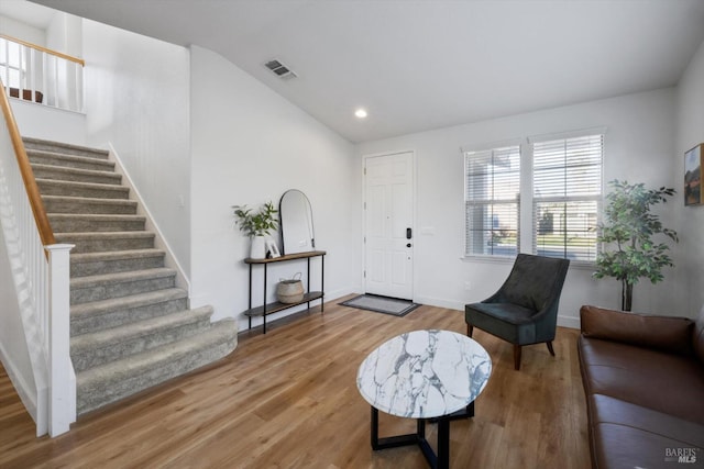 entryway with wood-type flooring and vaulted ceiling