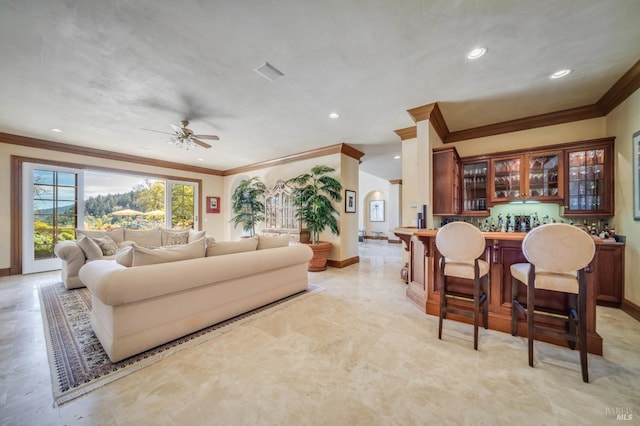 living room with crown molding, ceiling fan, and bar