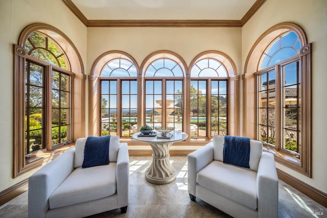 sitting room with crown molding and a wealth of natural light