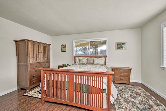 bedroom with dark wood-type flooring and baseboards