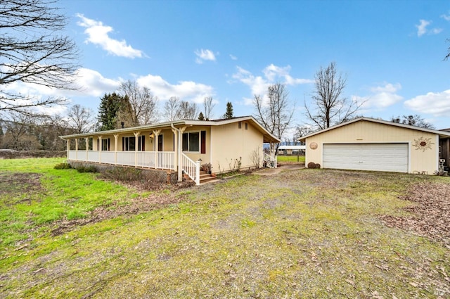 view of front of property with a garage, covered porch, driveway, and a yard