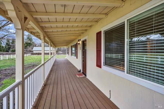 wooden deck featuring fence and a porch