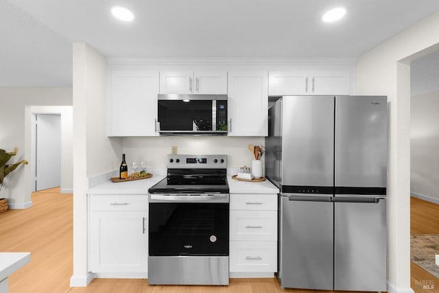 kitchen featuring stainless steel appliances, white cabinetry, and light wood-type flooring