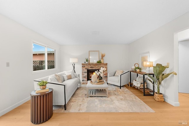 living room featuring a brick fireplace and light hardwood / wood-style flooring