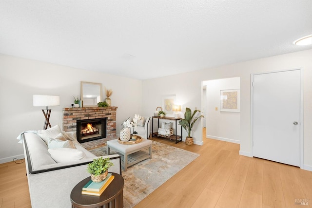 living room with a fireplace and light wood-type flooring