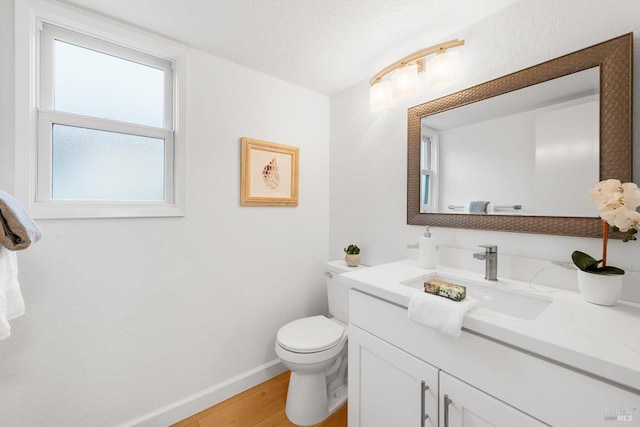 bathroom with vanity, toilet, hardwood / wood-style floors, and a textured ceiling