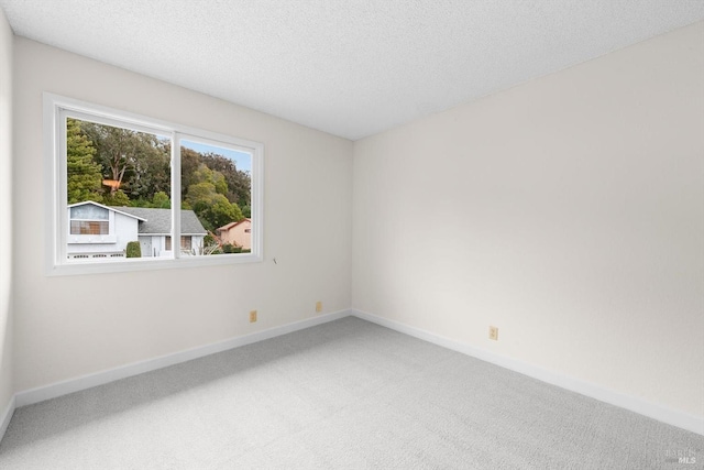 carpeted empty room with a textured ceiling