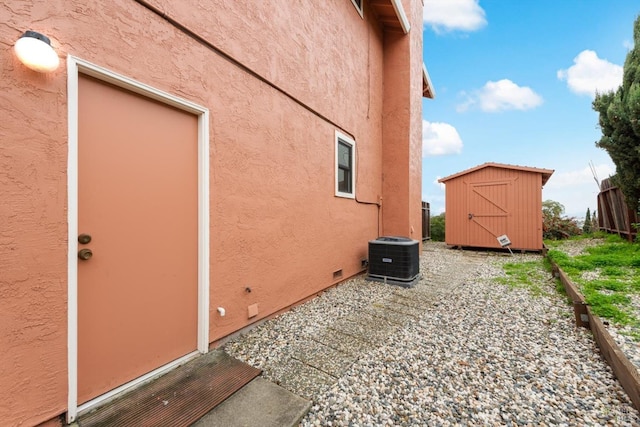 view of side of property with a storage unit and central air condition unit