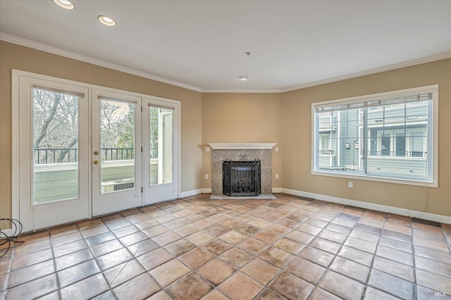 unfurnished living room with crown molding, a healthy amount of sunlight, and a high end fireplace