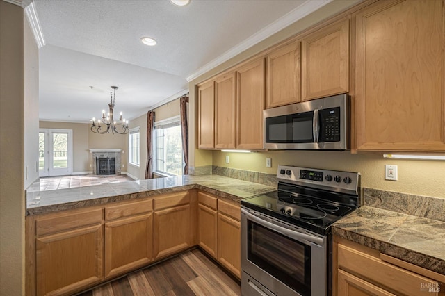 kitchen featuring appliances with stainless steel finishes, wood-type flooring, a chandelier, kitchen peninsula, and crown molding