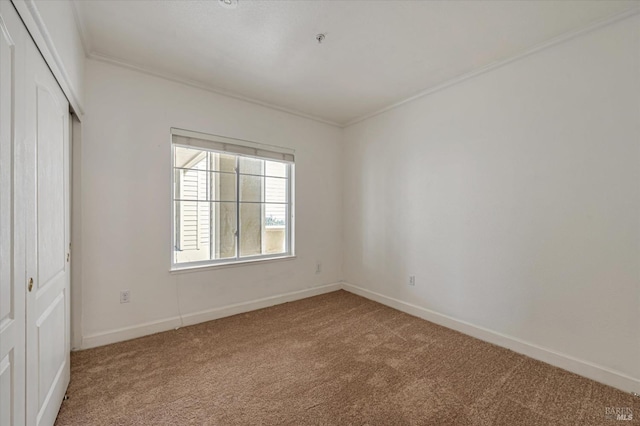 unfurnished bedroom with carpet floors, ornamental molding, and a closet