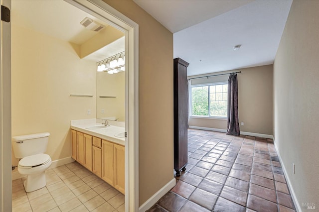 bathroom featuring tile patterned flooring, vanity, and toilet